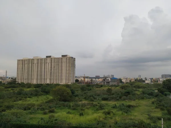 バンガロール カルナータカ州 2020年6月28日 ヘブル近郊の雨の多い雲の背景または夕景のある都市におけるインドの黄色のマルチフロアアパートメントの閉鎖 — ストック写真