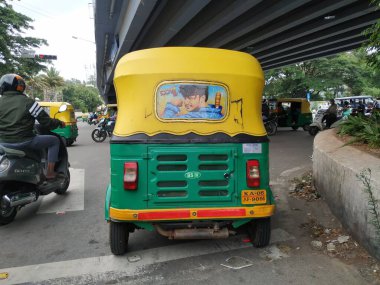 Bangalore, Karnataka / India-Aug 07-2020: Sarı ve Yeşil renkli otomobil Rickshaw 'ın yakın çekimde durduğu yer. Ünlü Kannada Aktörü Yıldız Darshan 'ın Arkaya Resmini Yapıyor