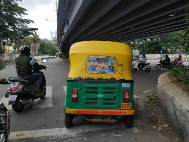 Bangalore, Karnataka / India-Aug 07-2020: Sarı ve Yeşil renkli otomobil Rickshaw 'ın yakın çekimde durduğu yer. Ünlü Kannada Aktörü Yıldız Darshan 'ın Arkaya Resmini Yapıyor