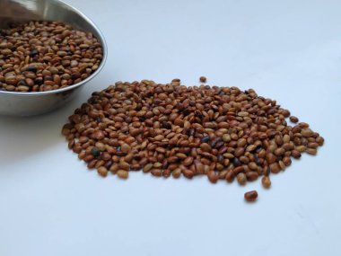 Beyaz zemin üzerinde izole edilmiş Çelik Kupa 'dan Dağılmış At Gram tohumlarının yakın çekimi