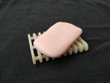 Siyah arkaplanda pembe renkli sabun, plastik sabun tutacağı ve tepsi izole edilmiş.