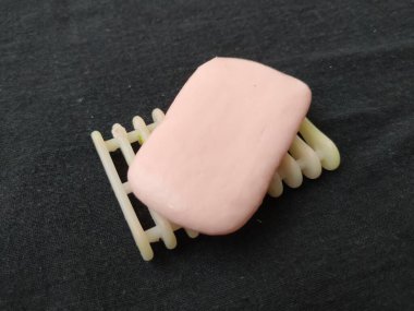 Siyah arkaplanda pembe renkli sabun, plastik sabun tutacağı ve tepsi izole edilmiş.