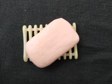 Siyah arkaplanda pembe renkli sabun, plastik sabun tutacağı ve tepsi izole edilmiş.