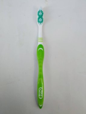 Bangalore, Karnataka / Hindistan-12 Şubat 2020: Yeni ve Kullanılmamış Yeşil Renklerin Kapanışı Oral-B Plastik diş fırçası beyaz bir arkaplanda izole edildi