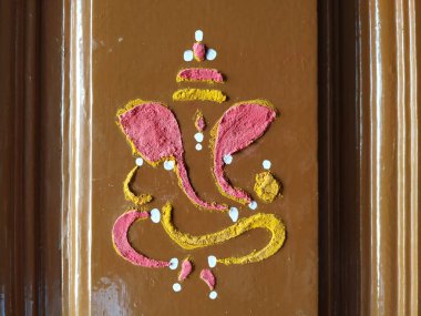 Efendi Vinayaka 'nın ya da Ganesha' nın yaklaşması. Zerdeçal tozu ve kumkum ile evin ana kapısını çiziyor.