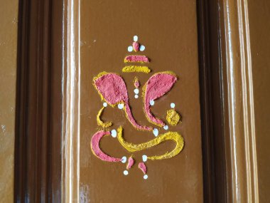 Efendi Vinayaka 'nın ya da Ganesha' nın yaklaşması. Zerdeçal tozu ve kumkum ile evin ana kapısını çiziyor.