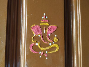 Efendi Vinayaka 'nın ya da Ganesha' nın yaklaşması. Zerdeçal tozu ve kumkum ile evin ana kapısını çiziyor.