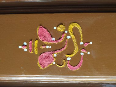 Efendi Vinayaka 'nın ya da Ganesha' nın yaklaşması. Zerdeçal tozu ve kumkum ile evin ana kapısını çiziyor.