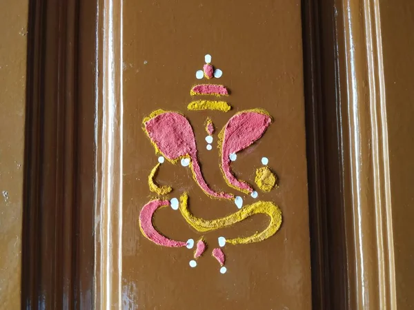 Efendi Vinayaka 'nın ya da Ganesha' nın yaklaşması. Zerdeçal tozu ve kumkum ile evin ana kapısını çiziyor.