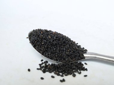 Chia ya da Kama Kasturi 'nin yakın plan çekimleri Çelik bir kaşıkta beyaz bir arkaplanda izole edilmiş.