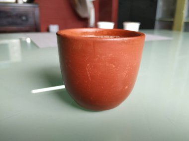 El Yapımı Kil ya da Kum Kahve Kupasının yakın plan görüntüsü beyaz arka planda izole