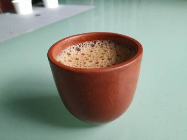 El Yapımı Kil ya da Kum Kahve Kupasının yakın plan görüntüsü beyaz arka planda izole