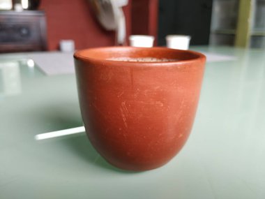 El Yapımı Kil ya da Kum Kahve Kupasının yakın plan görüntüsü beyaz arka planda izole