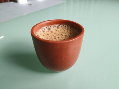 El Yapımı Kil ya da Kum Kahve Kupasının yakın plan görüntüsü beyaz arka planda izole