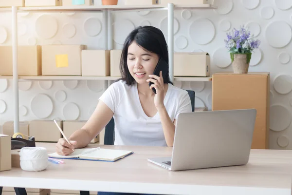 Shipping shopping online ,Asian young woman start up small business owner writing address on cardboard box at workplace.small business entrepreneur ,woman working at home/, Selling online concept