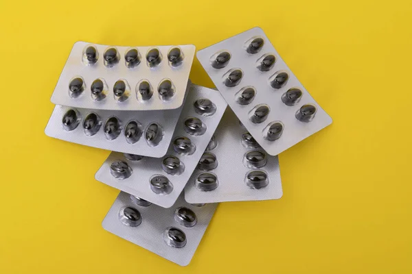Pills set on the yellow paper background