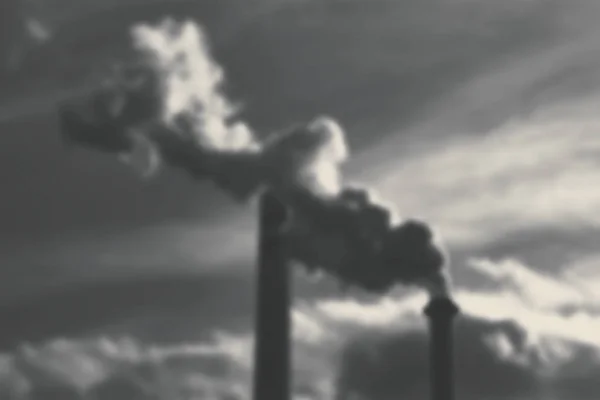 Abstract industrial smoke from chimneys with grey sky