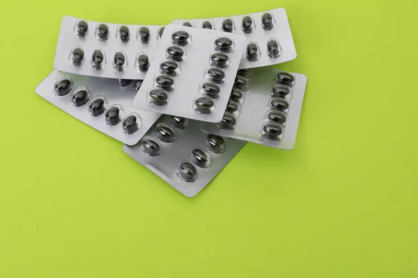 Pills set on the green paper background