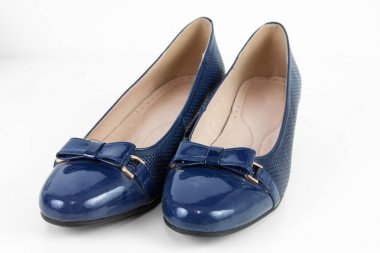 Beyaz arka planda koyu mavi kadın ayakkabıları.