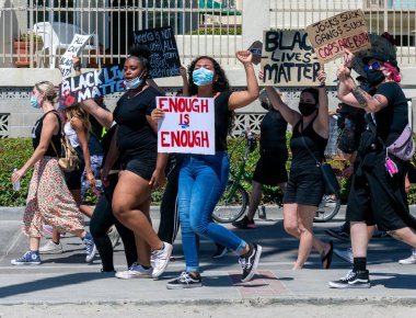 San Diego, CA / USA - 4 Temmuz 2020: Siyahi Hayatlar Önemli Kadın Protestocular Kaldırımda yürüyor, ellerinde ırkçılığı ve polis şiddetini protesto eden el yapımı protesto işaretleri taşıyorlar.