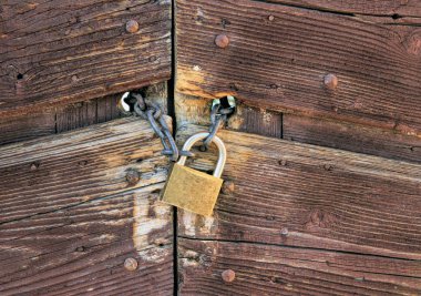 Ahşap bir kapı kapanış bir zincir üzerinde metalik asma kilit