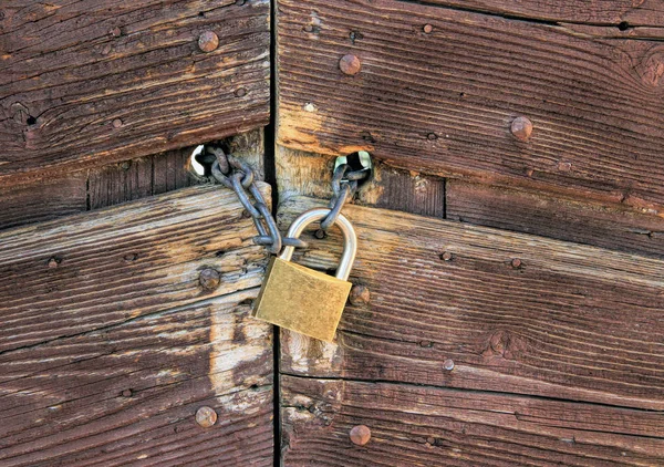 Ahşap bir kapı kapanış bir zincir üzerinde metalik asma kilit