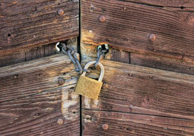 Ahşap bir kapı kapanış bir zincir üzerinde metalik asma kilit