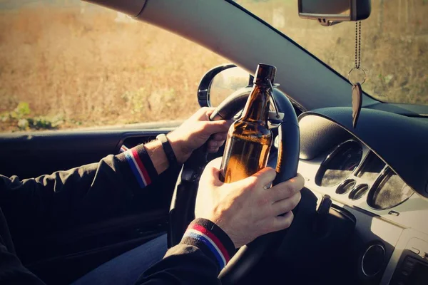 Pijany Mężczyzna Prowadzi Samochód Butelką Alkoholu Ręku Mężczyzna Trzyma Kierownicę — Zdjęcie stockowe