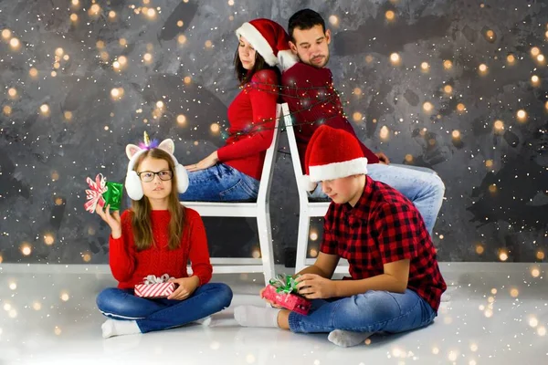 İki çocuk Noel ışıklarıyla ebeveynlerini bağladı ve paketlenmemiş Noel hediyeleriyle. Ebeveynler esaret altında. Noel başlayabilir. Çocuklar hediyeleri keşfeder.