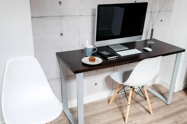 Bilgisayarlı minimal bir masa birkaç kahve ve bisküvi. Modern çalışma alanı