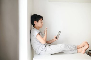 Sosyal ağlar için selfie çeken mutlu çocuk. Evdeki çocuk odasında.