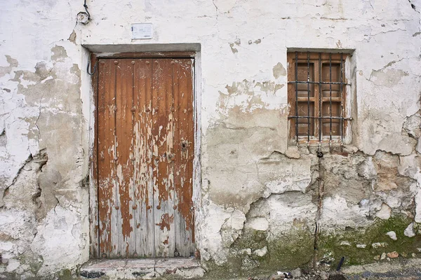 White painted ruined house facade with vintage wooden door — Stock Photo, Image