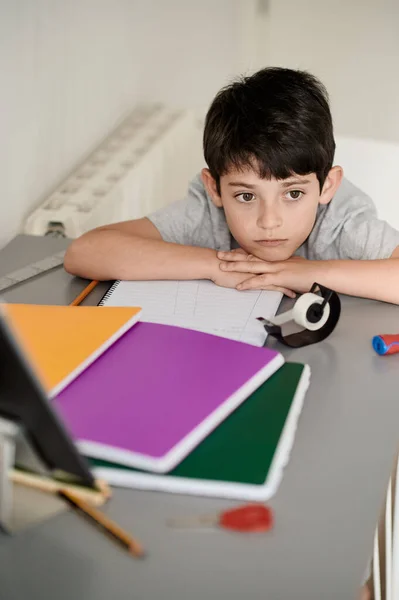 Stresli çocuk ödevini yapıyor. Çalışma masasındaki çocuk stres hareketleriyle ödev yapıyor. Stresli yüzüyle ev ödevi yapan tembel çocuk.. — Stok fotoğraf