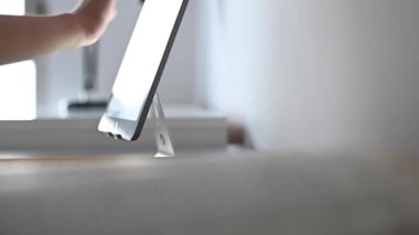 Egzersiz yaparken tablet kullanan bir çocuk. Stresli çocuk ödevini yapıyor. Çalışma masasındaki çocuk stres hareketleriyle ödev yapıyor. Stresli yüzüyle ev ödevi yapan tembel çocuk..