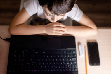 Dizüstü bilgisayarın önünde duran biri.