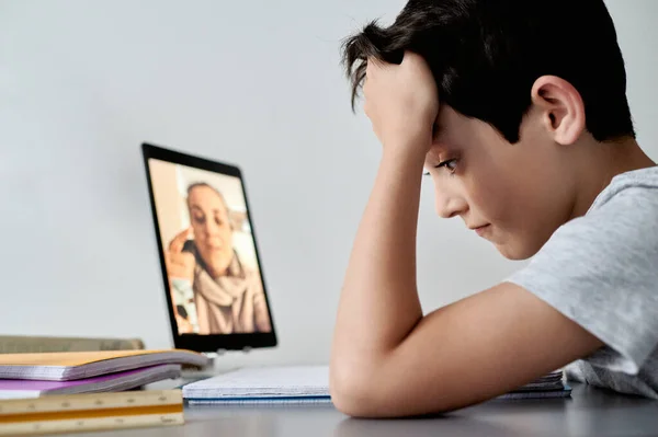 Evden online derslere katılan mutlu küçük çocuk. Karantina sırasında okul eğitimi ve sosyal uzaklık
