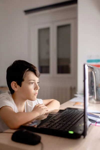 Ένα αγόρι που χρησιμοποιεί ένα φορητό υπολογιστή στο χώρο εργασίας του — Φωτογραφία Αρχείου