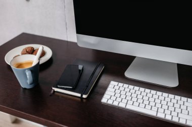 Bilgisayarlı minimal bir masa birkaç kahve ve bisküvi. Modern çalışma alanı