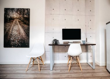 Bilgisayarı ve sandalyeleri olan küçük bir çalışma alanı