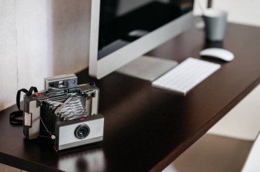 Masada bilgisayarlı, antika kameralı bir masa.