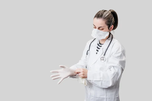 Retrato médico femenino en guantes y máscara, aislado en gris — Foto de Stock