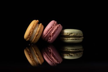 Yansıtıcı siyah arkaplanda izole edilmiş badem kurabiyeleri