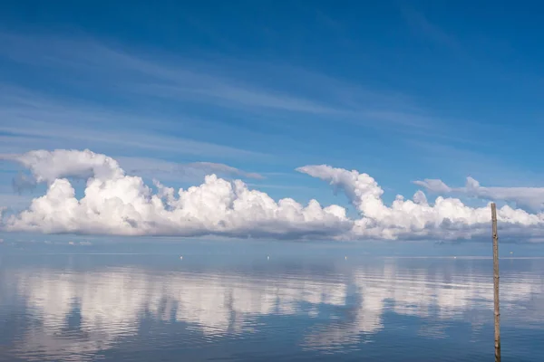 Cloud reflection, with a mirror-smooth North Sea, wind turbines in the background.