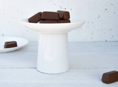 Beyaz arka planda bir tabakta çikolata şekeri.