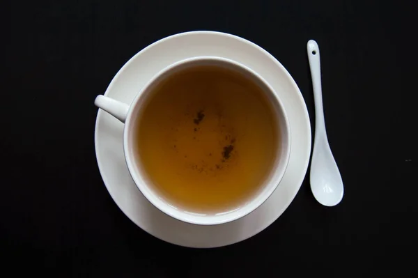 Biała Filiżanka Herbaty Spodkiem Łyżką Ciemnym Tle — Zdjęcie stockowe