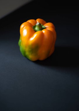 Bahçeden taze portakal biberi ve siyah bir arka plan..