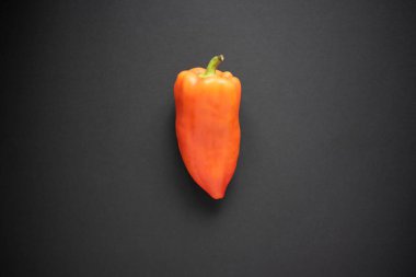 Bahçeden taze portakal biberi ve siyah bir arka plan..