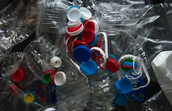 Lots of plastic bottles and color plastic caps and rings. Sorting of garbage. Plastic recycling. No plastic surgery. Responsible attitude to the environment. Pattern.
