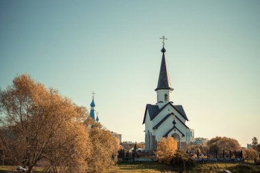 Güneşli bir sonbahar gününde sonbahar ağaçları arasında iki güzel ve farklı kilise..
