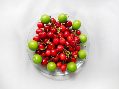 Beyaz izole bir zemin üzerinde kiraz ve yeşil erik